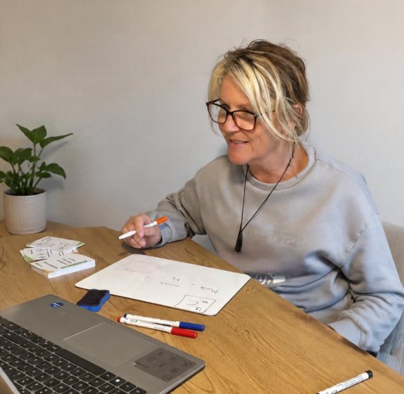 Babs at her desk with a mini whiteboard and revision flashcards
